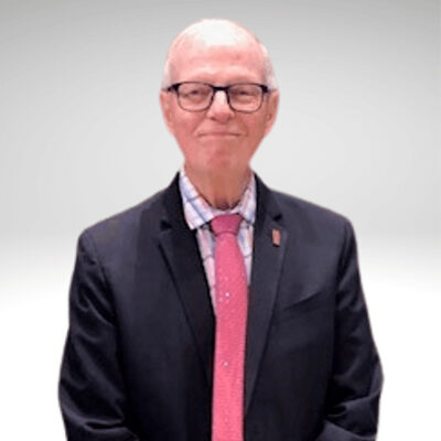 Elderly man in suit with red tie smiling