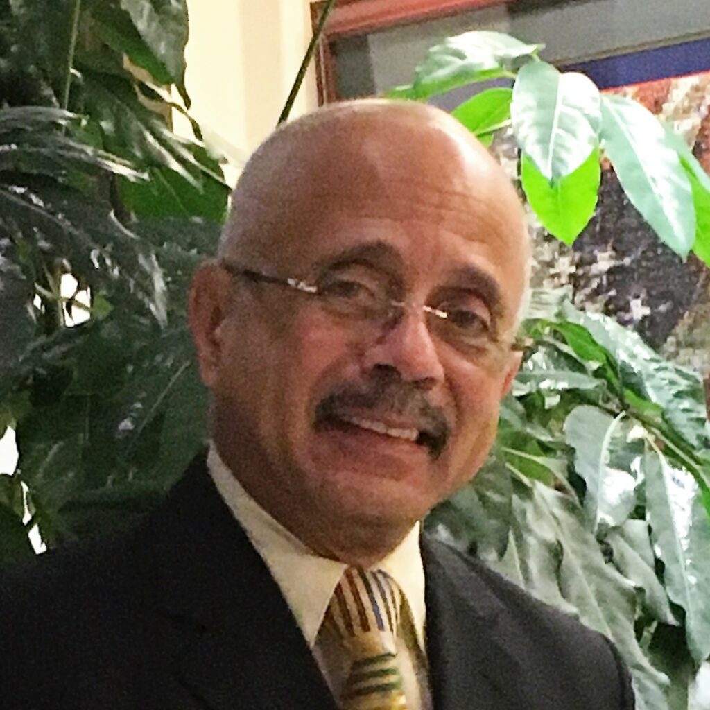 Smiling man in suit with colorful tie.