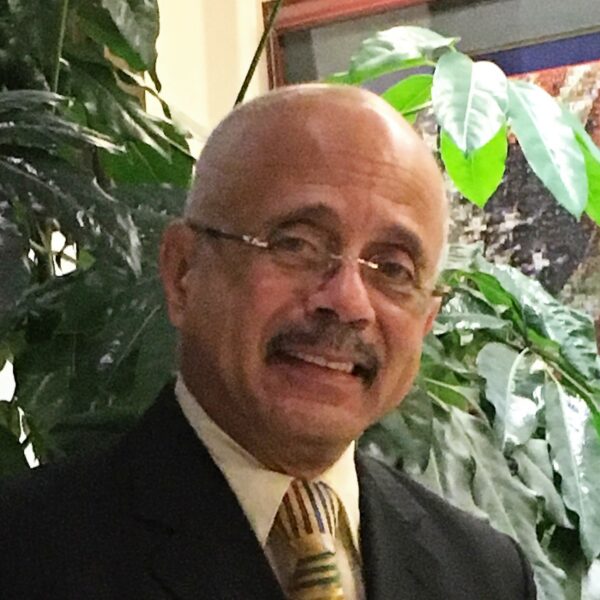 Smiling man in suit with colorful tie.