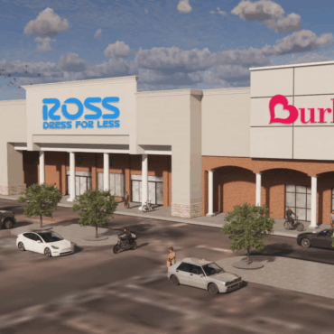 Shopping center with five stores and vehicles outside.